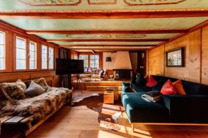 a living room with two couches and a television at Chalet Ruthchen in Grindelwald