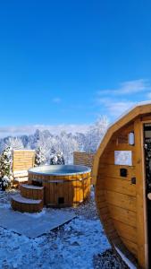 カルパチにあるWidokowo - Domki z widokiem na Śnieżkę z Jacuzzi i Saunąの隣の雪の中のホットタブ