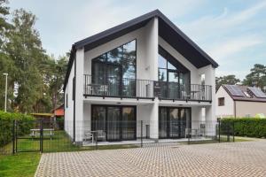 a house with large windows and a balcony at Być Morze in Pobierowo