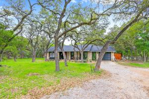 a house with a lot of trees in front of it at Red Bird Cottage in Wimberley