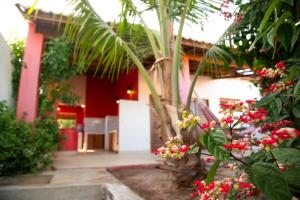 a house with a red door and some flowers at Casa CLAUDIA in Fortim