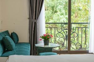 un soggiorno con un divano e una finestra di LÉ BOISE HOTEL Đà Lạt a Da Lat