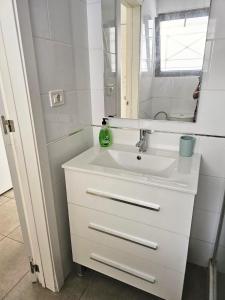 a white bathroom with a sink and a mirror at The Poolside Haven, Azure Dreams in Los Cristianos