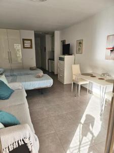 a room with two beds and a table and a desk at The Poolside Haven, Azure Dreams in Los Cristianos +14 photos