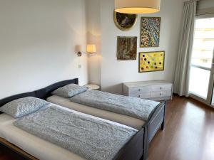 a bedroom with two beds and a window at Al Lido by Fewotessin in Locarno +19 photos