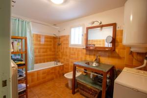 a bathroom with a sink and a toilet and a mirror at La maison de famille in Mussidan