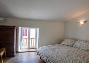 a bedroom with a bed and an open window at La maison de famille in Mussidan