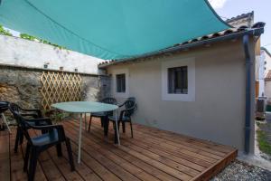 a wooden deck with a table and chairs on it at La maison de famille in Mussidan