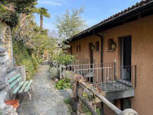 a house with a bench next to a walkway at Belvedere by Fewotessin in Orselina