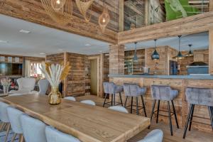 a dining room with a wooden table and chairs at Chalet des rêves in Megève