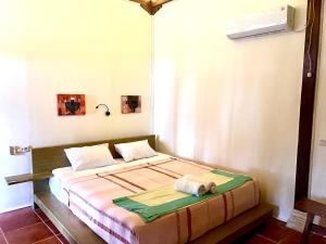 a bedroom with a bed with a towel on it at Arys Lagoon Bungalow & Hotel in Karimunjawa