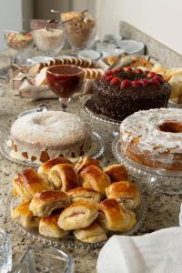 a table full of cakes and other desserts on plates at Hotel Nacional Inn São Paulo - Próximo ao COPAN in São Paulo