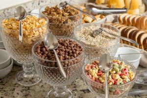 a group of glass bowls filled with cereal and nuts at Hotel Nacional Inn São Paulo - Próximo ao COPAN in São Paulo