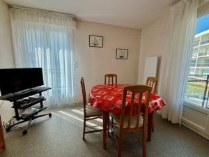 une salle à manger avec une table, des chaises et une télévision dans l'établissement Quiberon - 2 pièces, 40m², 4 pers, parking, balcons, près de la mer - FR-1-478-26, à Quiberon