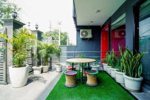 a patio with a table and a bunch of potted plants at Saltstayz Express -Medicity Near Medanta Hospital in Gurgaon