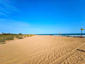 a sandy beach with people flying a kite at Apartamento loft en Castelldefels junto la playa in Castelldefels