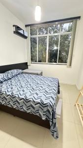 里约热内卢Avenida NOSSA SENHORA DE COPACABANA 363 TRES QUARTOS 5 CAMAS A 200 METROS DA PRAIA DE COPACABANA的一间卧室，里面有一张床和一扇大窗户。