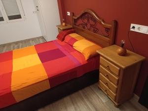 a bedroom with a colorful bed and a dresser at El Hogar del Castañar - Alojamiento en El Tiemblo in El Tiemblo