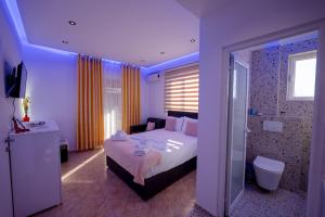 una habitación de hotel con una cama y una ducha en Vila Veli Brothers, en Sarandë