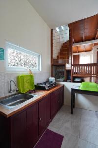a kitchen with a sink and a counter top at Villa Kayu Ciwidey in Panundaan