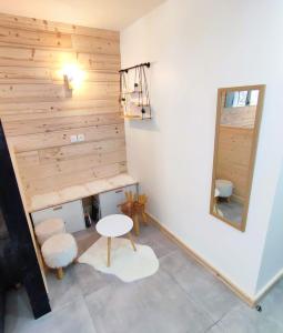 a room with a wooden wall with a table and a mirror at Le Bois Cosy appartement 4 étoiles 6 personnes, ACCES SKI ALPE D'HUEZ GRAND DOMAINE A 3 K M in Allemont
