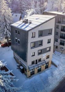 ein großes Gebäude im Schnee mit schneebedeckten Bäumen in der Unterkunft Dream Luxury Jahorina in Jahorina