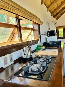a kitchen counter with a stove top oven next to a window at Complejo Las Carmelas in Punta Del Diablo