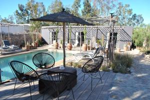 a patio with chairs and an umbrella next to a pool at Maison Sidi et Lalla in Essaouira