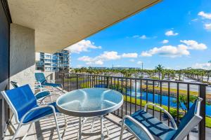 a balcony with a table and chairs and a view of the water at Our House at the Beach 201W by Beachside Management in Siesta Key