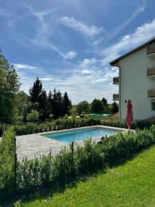 a swimming pool in a yard next to a building at Apartmány Chalet Trubárka in Trenčín