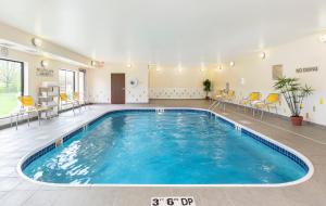 a large pool in a room with chairs and tables at Fairfield Inn & Suites Springfield in Springfield