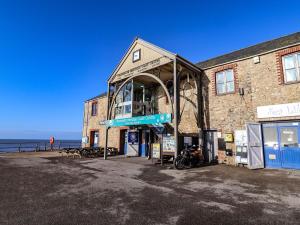 a building with a sign on it next to the ocean at Charleston Cottage in Bridport