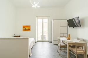 a white room with a bed and a table with chairs at Dimora Borbonica in Ercolano
