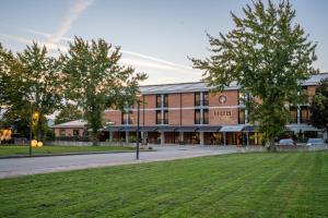 a large brick building with trees in front of it at Hub Hotel in Gubbio