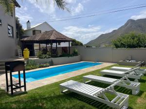 a backyard with a swimming pool and a house at Bird's View Guest Accommodation in Hermanus