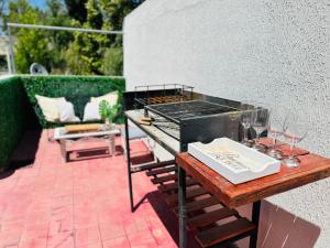 门多萨Lujoso Loft en la mejor ubicación!的露台上的烧烤架,配以葡萄酒