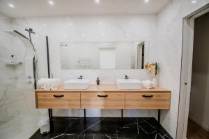 a bathroom with two sinks and a mirror at Chez Robin T3 Castelsarrasin in Castelsarrasin +15 photos