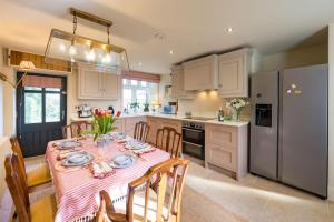 eine Küche mit einem Tisch und einem rosa Tischtuch in der Unterkunft The Garden Cottage in Craven Arms