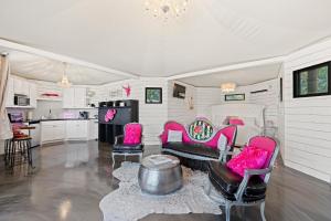 FischerThe Palace at Mystic Hills Ranch的客厅配有粉红色的椅子和桌子