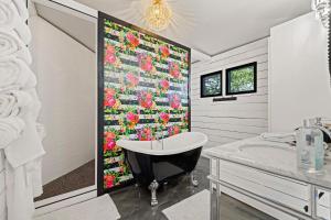 FischerThe Palace at Mystic Hills Ranch的带浴缸的浴室，墙上挂着花被