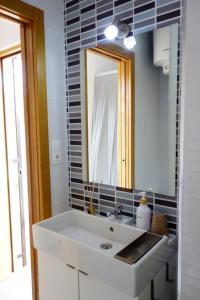Un baño con un lavabo blanco y un espejo. en STUDIO OHANA, en Torremolinos