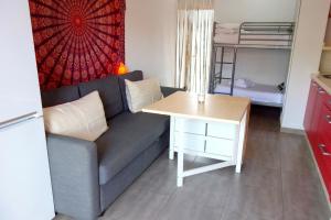 una sala de estar con un sofá y una mesa en STUDIO OHANA, en Torremolinos 11 fotos más