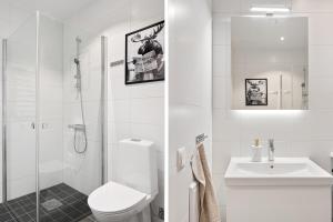 a white bathroom with a toilet and a sink at La Nordic Chic with cheap parking in Stockholm