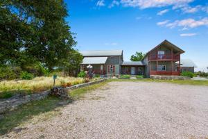 una casa con un vialetto di ghiaia davanti di Swing On Inn- Hankie Pankie Cottage a Dripping Springs