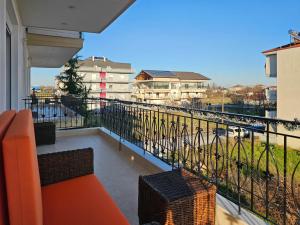 a balcony with an orange couch and a view at Dakis Luxury Apartments in Katerini