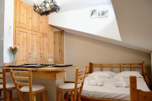 une chambre avec un lit, une table et des chaises dans l'établissement Hostdomus - Rifugio delle Stelle, à Sestrières