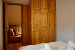 une chambre avec un grand placard en bois et un lit dans l'établissement Hostdomus - Rifugio delle Stelle, à Sestrières 3 autres photos