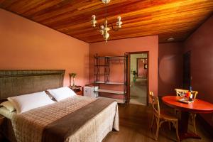 une chambre avec un lit et une table dans une pièce dans l'établissement Ecopousada Serra Verde, à Glaura
