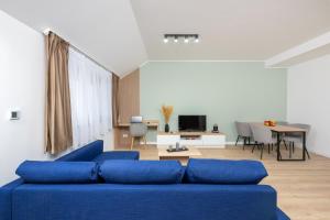 a living room with a blue couch and a table at ELIZA Apartments - powered by NEO - private parking in Timişoara
