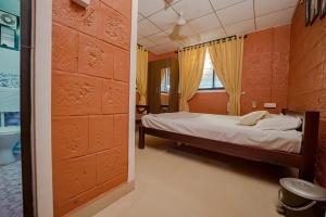 a small bedroom with a bed and a window at UDUPI HOMESTAY - Sunrise Home in Udupi